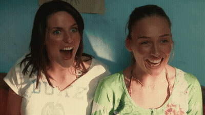 Two Women Are Laughing With One Wearing A Shirt That Says Duke On It GIF