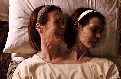 Two Women Are Laying Next To Each Other In A Hospital Bed . One Of The Women Has Two Heads . GIF