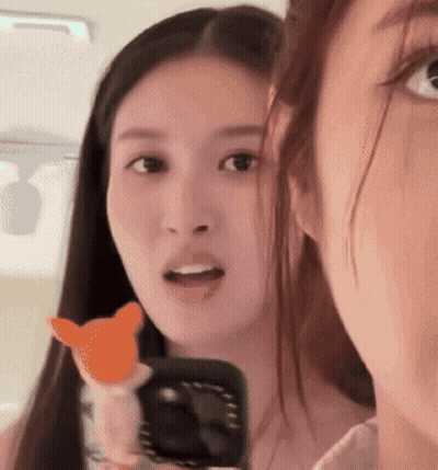 Two Women Are Looking At Each Other And One Is Holding A Cat Toy GIF