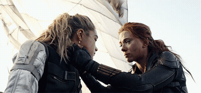 Two Women Are Looking At Each Other And One Is Holding The Other 'S Hand GIF