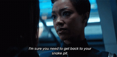 Two Women Are Looking At Each Other And One Of Them Is Saying I 'M Sure You Need To Get Back To Your Snake Pit GIF