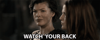 Two Women Are Looking At Each Other And The Words Watch Your Back Are Visible GIF