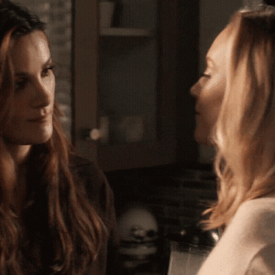 Two Women Are Looking At Each Other In A Kitchen GIF
