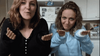 Two Women Are Making Funny Faces In Front Of A Refrigerator That Has A Sticker On It That Says " I Love You " GIF
