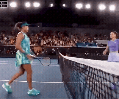 Two Women Are Playing Tennis On A Court And One Is Wearing A Blue Dress GIF