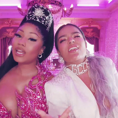 Two Women Are Posing For A Picture And One Has A Necklace That Says God On It GIF