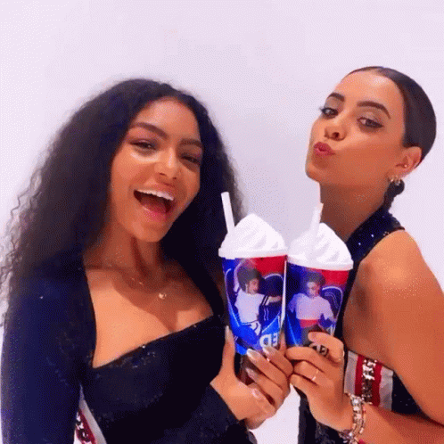 Two Women Are Posing For A Picture While Holding A Cup That Says Pepsi GIF