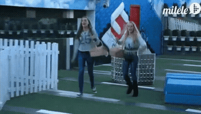 Two Women Are Running In Front Of A Sign That Says Milele GIF