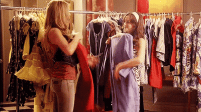 Two Women Are Shopping For Clothes In A Store . GIF
