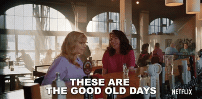 Two Women Are Sitting At A Table In A Restaurant With The Words " These Are The Good Old Days " GIF
