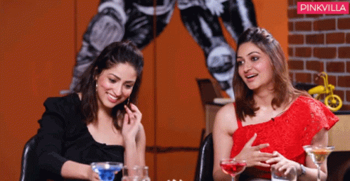 Two Women Are Sitting At A Table With Drinks And A Pinkvilla Logo In The Background GIF