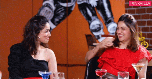 Two Women Are Sitting At A Table With Drinks And A Pinkvilla Logo In The Background GIF