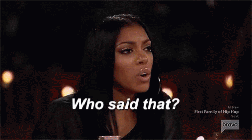 Two Women Are Sitting At A Table With Glasses Of Champagne And A Fire In The Background . GIF
