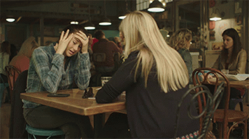 Two Women Are Sitting At A Table With The Words " I Need To Get Out Of This Town As Soon As Possible " Below Them GIF