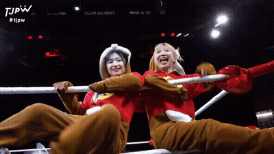 Two Women Are Sitting In A Boxing Ring With The Tjpw Logo On The Bottom GIF