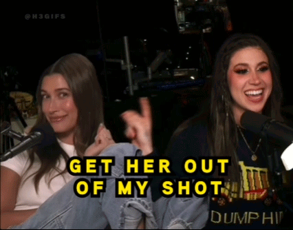Two Women Are Sitting In Front Of Microphones With The Words Get Her Out Of My Shot On The Bottom GIF