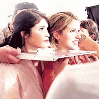 Two Women Are Sitting Next To Each Other And A Man Is Holding A Tablet . GIF