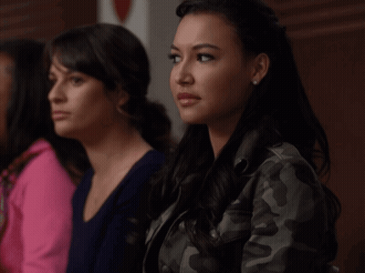 Two Women Are Sitting Next To Each Other And One Is Wearing A Camo Jacket GIF