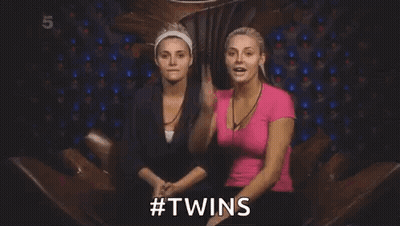 Two Women Are Sitting Next To Each Other In A Chair And One Of Them Is Holding A Card In Her Hand . GIF