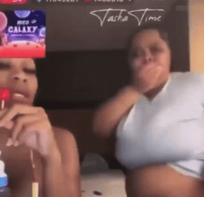 Two Women Are Sitting Next To Each Other In Front Of A Screen That Says ' Galaxy ' On It . GIF