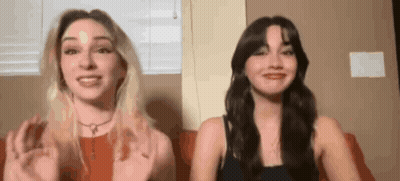 Two Women Are Sitting Next To Each Other On A Couch And Talking To Each Other . GIF