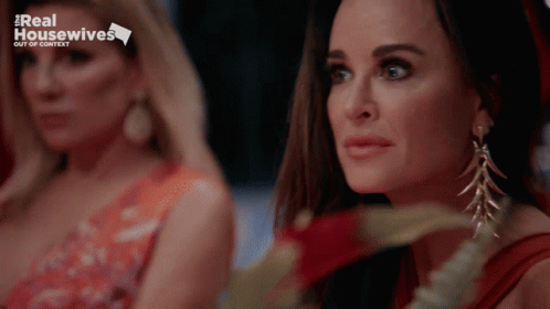 Two Women Are Sitting Next To Each Other With A Real Housewives Logo In The Background GIF