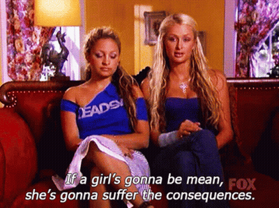 Two Women Are Sitting On A Couch And One Of Them Is Wearing A Shirt That Says " Deads " GIF