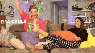 Two Women Are Sitting On A Couch And One Of Them Is Wearing A Shirt That Says Eita Chule On It GIF