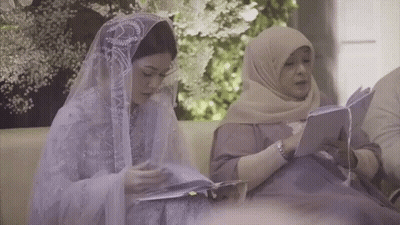 Two Women Are Sitting On A Couch Reading Books . GIF