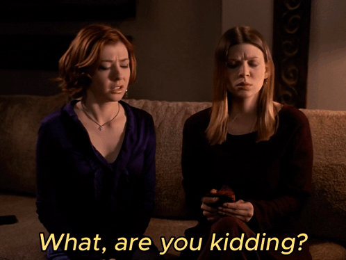 Two Women Are Sitting On A Couch With The Words What Are You Kidding GIF