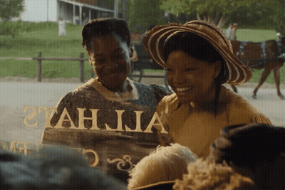 Two Women Are Smiling In Front Of A Sign That Says Tah Jia GIF
