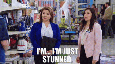 Two Women Are Standing In A Store Talking To Each Other And One Of Them Is Holding A Clipboard . GIF