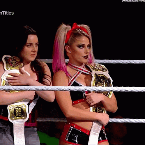 Two Women Are Standing In A Wrestling Ring And One Has A Title On Her Shoulder That Says Titles GIF