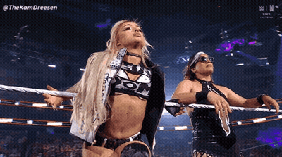 Two Women Are Standing In A Wrestling Ring With Ropes Around Their Necks . GIF
