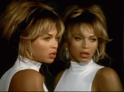 Two Women Are Standing Next To Each Other And Looking At Each Other . GIF