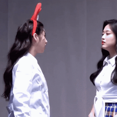 Two Women Are Standing Next To Each Other And One Has A Red Headband On GIF