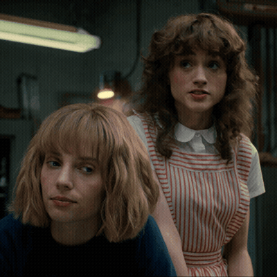 Two Women Are Standing Next To Each Other And One Is Wearing A Striped Dress GIF