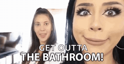 Two Women Are Standing Next To Each Other And One Of Them Is Making A Funny Face And Saying `` Get Outta The Bathroom !  GIF