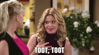 Two Women Are Standing Next To Each Other And One Of Them Is Saying Toot Toot . GIF