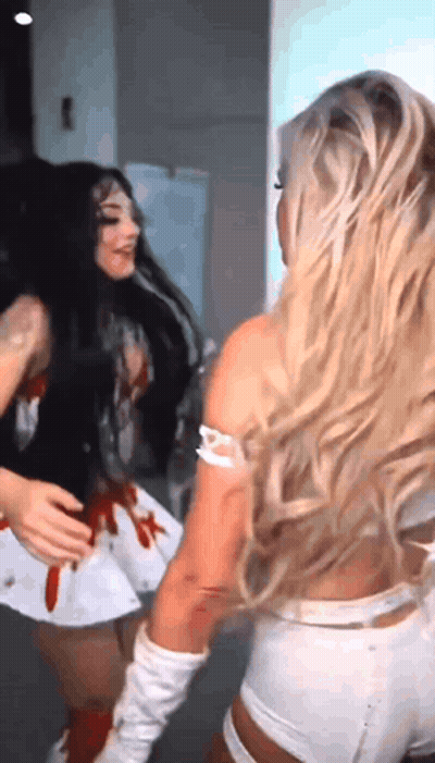 Two Women Are Standing Next To Each Other And One Of Them Is Wearing A Nurse Costume GIF