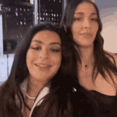 Two Women Are Standing Next To Each Other And Smiling For The Camera . GIF