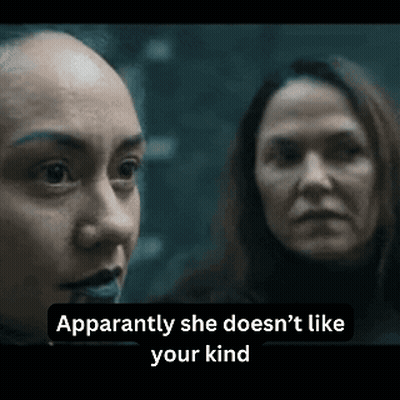 Two Women Are Standing Next To Each Other In A Dark Room . GIF