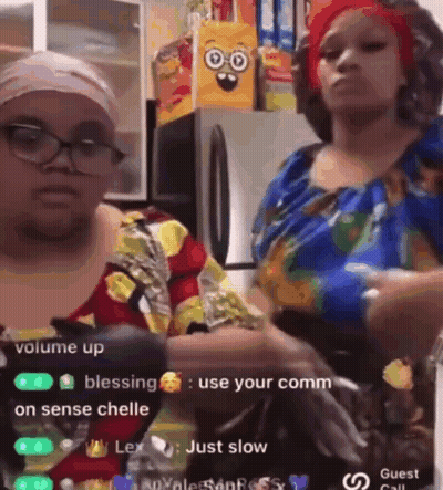 Two Women Are Standing Next To Each Other In A Kitchen And One Of Them Is Holding A Bottle Of Water . GIF