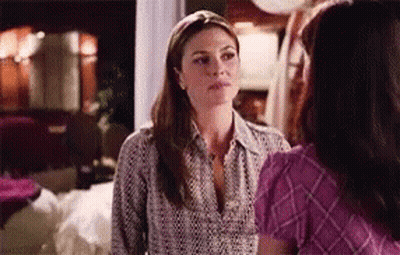 Two Women Are Standing Next To Each Other In A Living Room Talking To Each Other . GIF