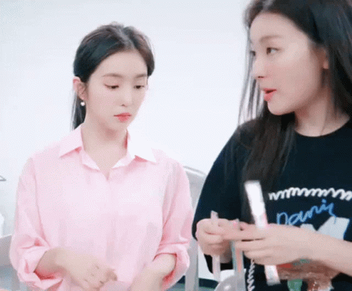 Two Women Are Standing Next To Each Other In A Room . GIF