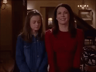 Two Women Are Standing Next To Each Other In A Room . GIF