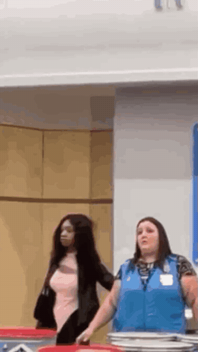 Two Women Are Standing Next To Each Other In A Room In A Store . GIF