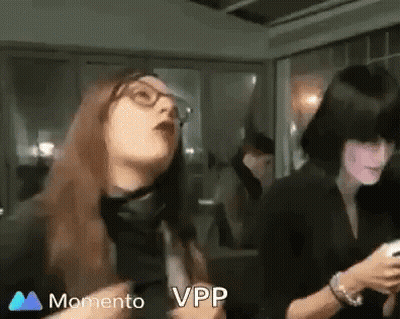 Two Women Are Standing Next To Each Other In A Room . One Of The Women Is Wearing Glasses . GIF