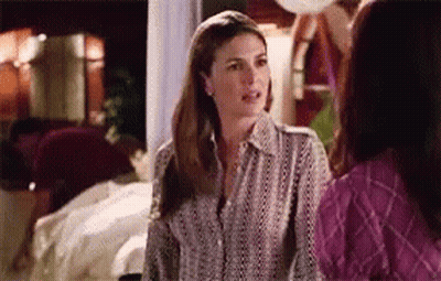 Two Women Are Standing Next To Each Other In A Room Talking To Each Other . GIF