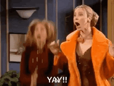 Two Women Are Standing Next To Each Other In A Room With Their Mouths Open And One Of Them Is Wearing An Orange Fur Coat GIF